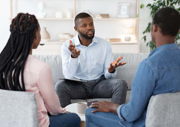 A therapist works with parents an their ABA clinic