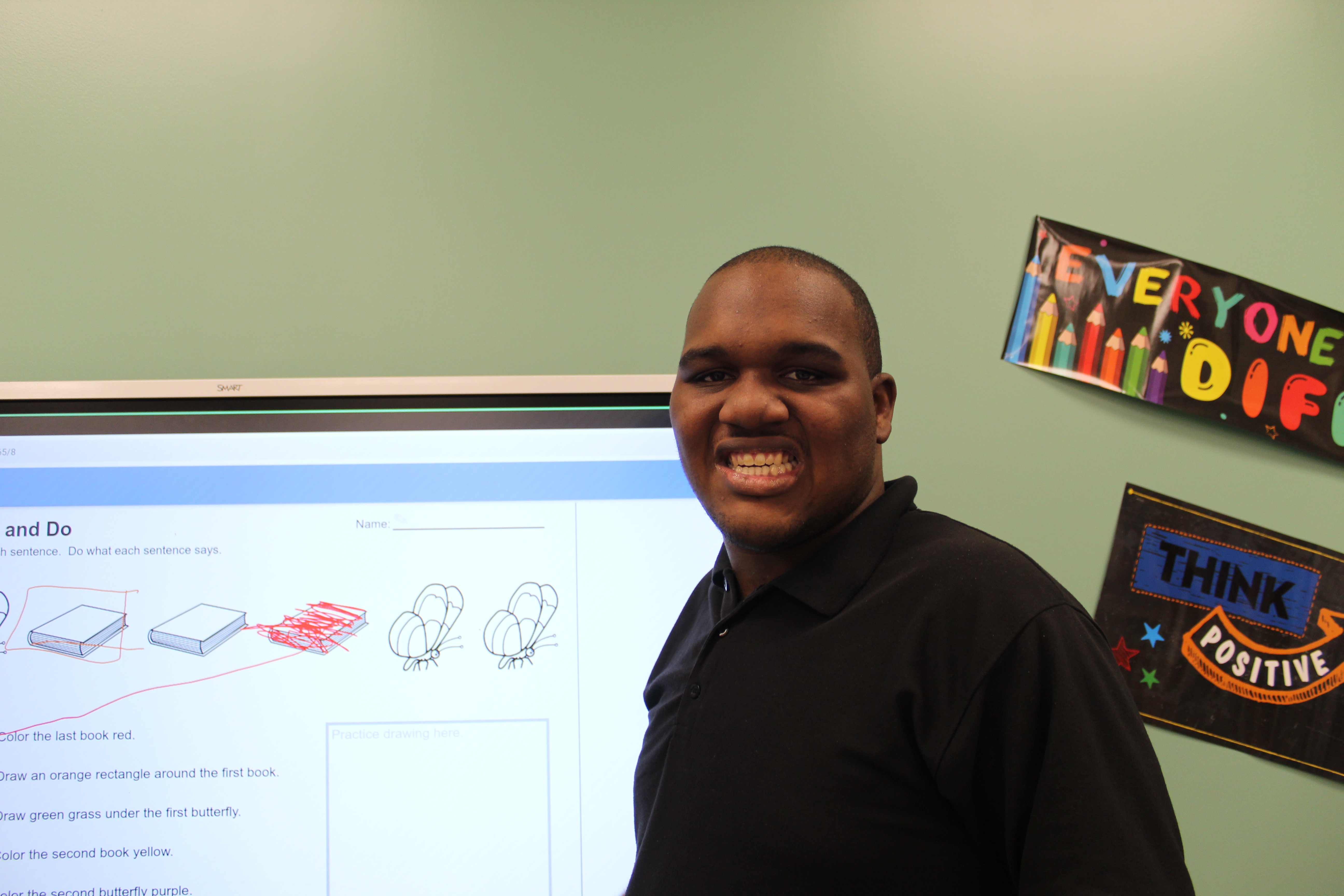 Autism student smiling at Smartboard