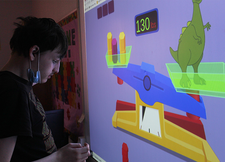 client with autism working at smart board mobile image